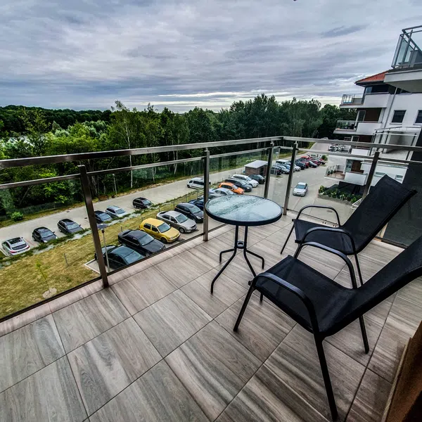 Balkon apartamentu w Ostródzie z widokiem na zielone otoczenie